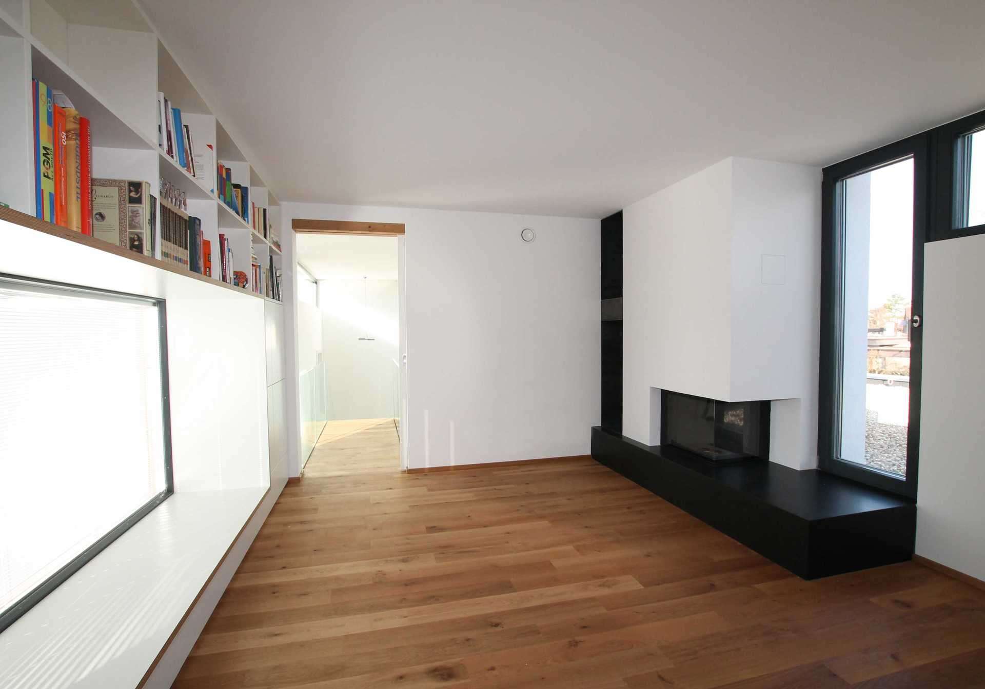 Bücherregal rund herum um Sitzfenster/Fenstersitz in weiß. Sitzfenster mit Holz verkleidet.